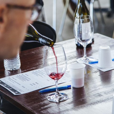 a person holding a bottle of wine on a table