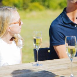 a woman sitting at a table with wine glasses