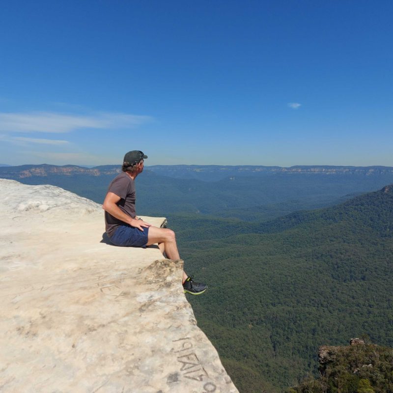 a man flying through the air on top of a mountain