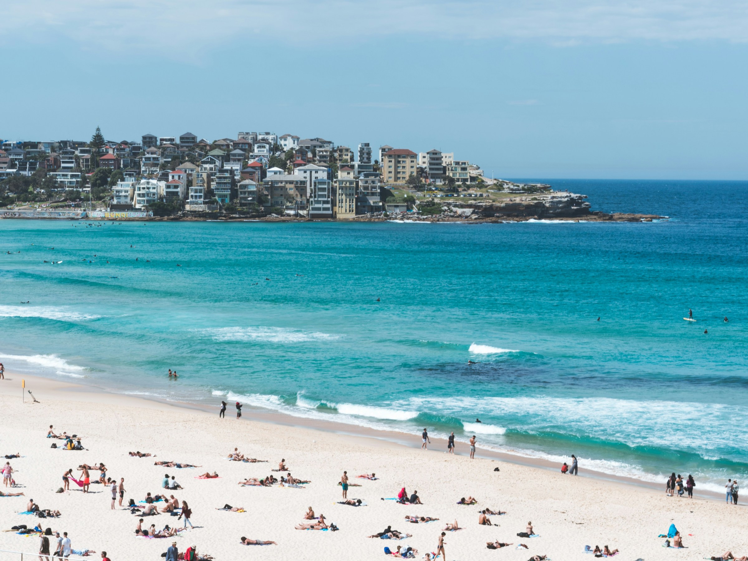 a group of people on a beach with Bondi Beach in the background
