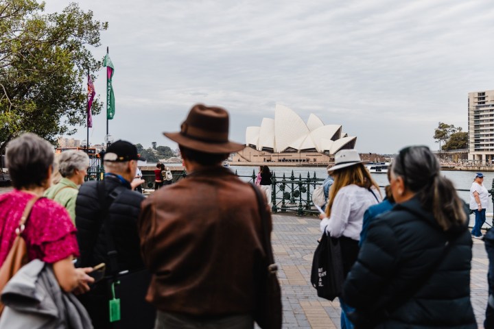 People standing by Sydney Harbour with the Opera House in the background.